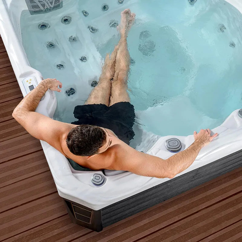 Outdoor Whirlpool 4 - 5 Personen winterfest Reluxis Budapest Life Wellis im Garten kaufen viereckig Detiailbild Mann drin