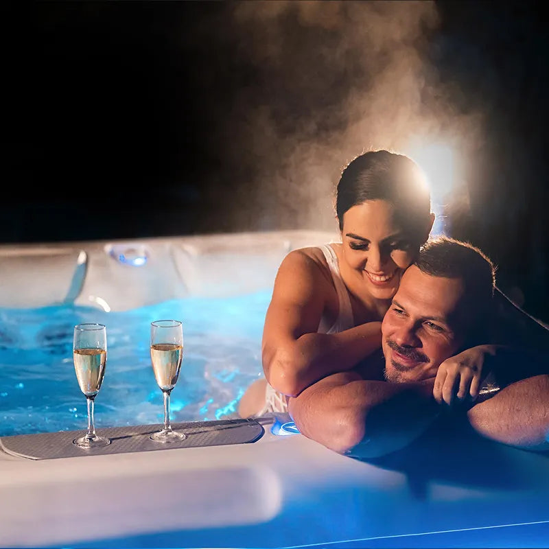 Whirlpool Garten 2 - 3 Personen winterfest Reluxis Teide Life Wellis kaufen Preis Outdoor freistehend rechteckig Detailbild Pärchen mit Sekt